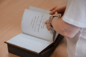 A person turning the pages of a leather bound book